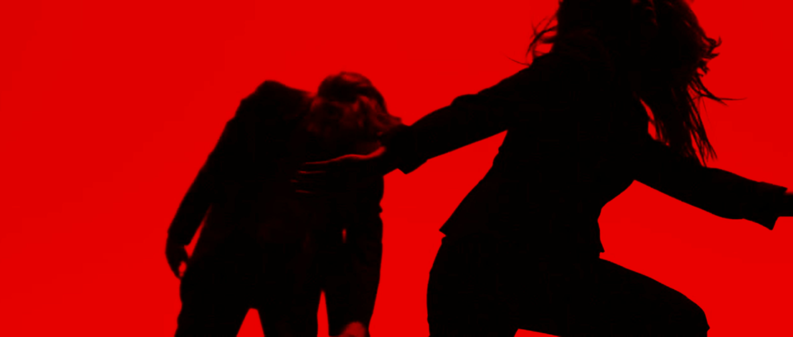 Two ballet dancers in silhouette against a saturated crimson LED backdrop, motion blur in the female dancer's hair as she gestures toward her partner — a still from the Play promo for Houston Ballet's Nine Sinatra Songs triple bill.